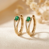 Gold hoop earrings with emerald accents
