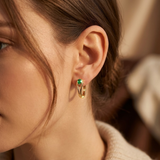 Gold hoop earrings with emerald accents