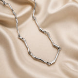 White gold necklace with intertwined wave pattern
